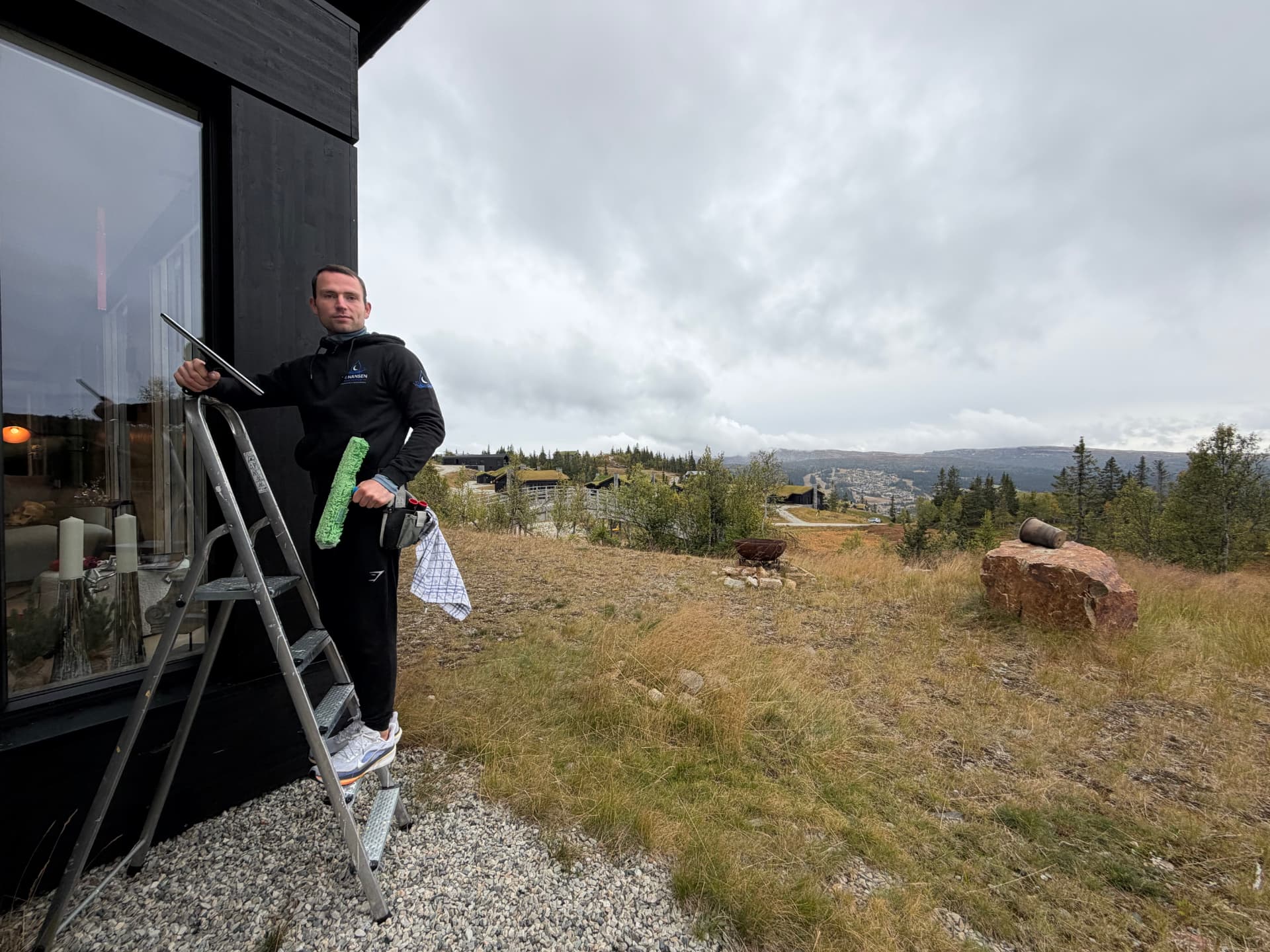 Johan Hansen med vindusvaskutstyr ved en hytte